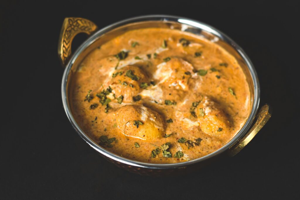 Flavorful dum aloo curry served in a traditional kadai, perfect for Indian cuisine lovers.
